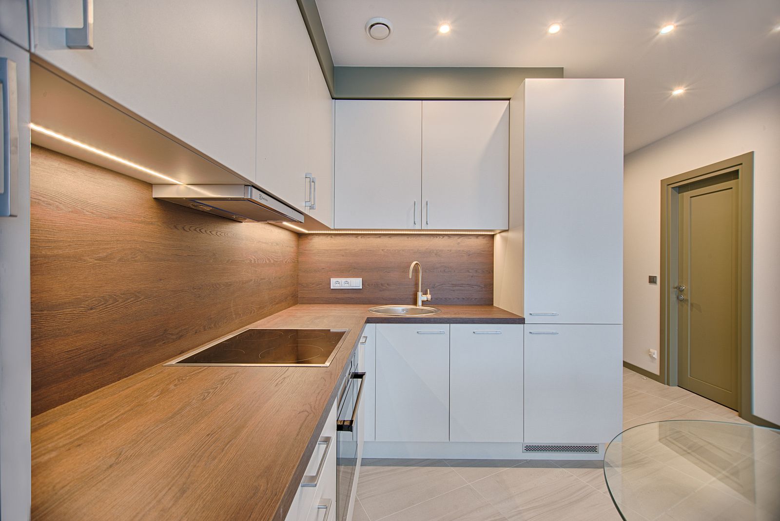 Modular kitchen in a 3 BHK Sarjapur Road home 2026, white and wood finish with tall unit by myNivasa