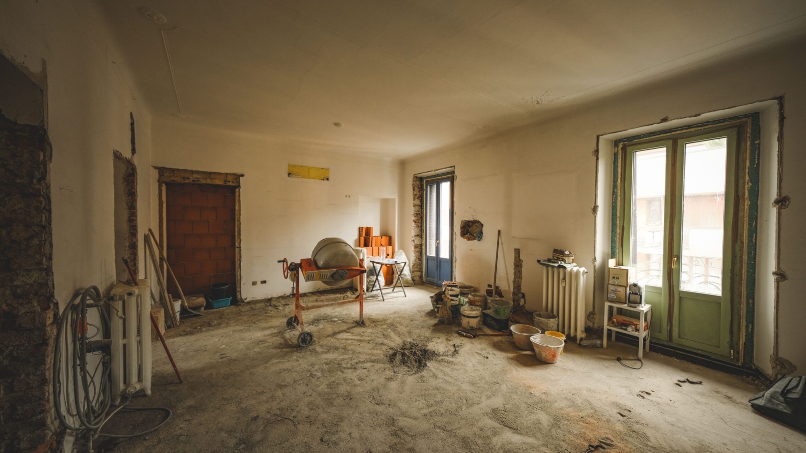 Home renovation costs per square foot in Bangalore 2026: living area stripped for renovation with cement mixer and fresh plaster by myNivasa