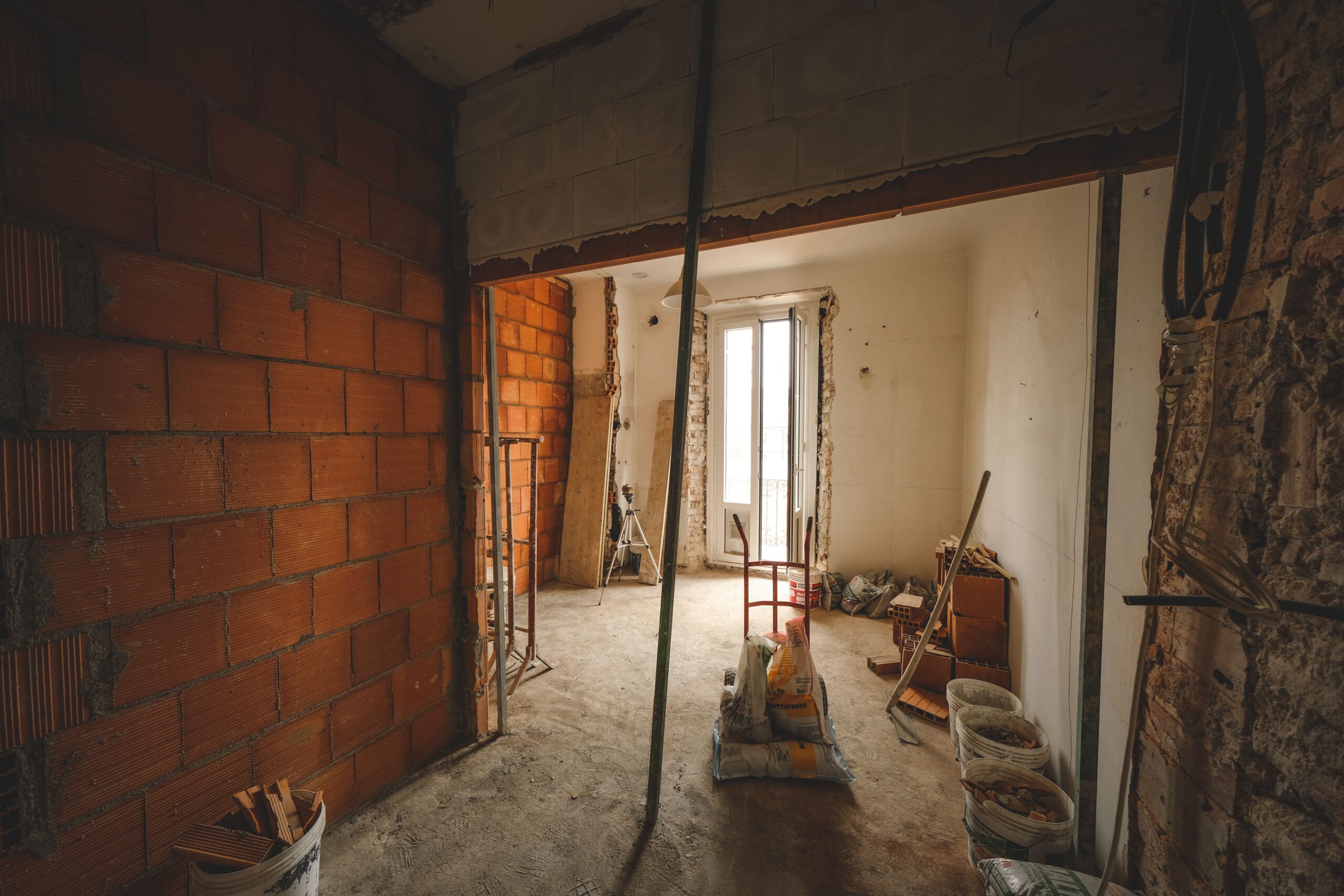 Wall demolition stage during home renovation in Bangalore 2026 exposing brick masonry before replastering by myNivasa