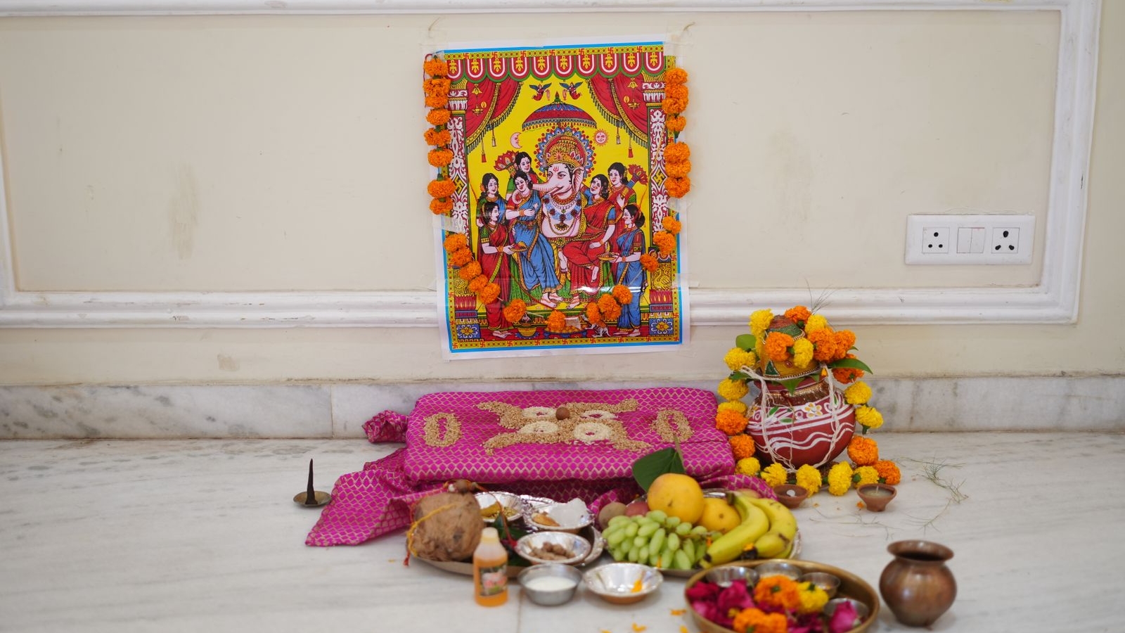 Pooja room design in a Bengaluru home 2026 with brass kalash, marigold garlands and marble flooring by myNivasa