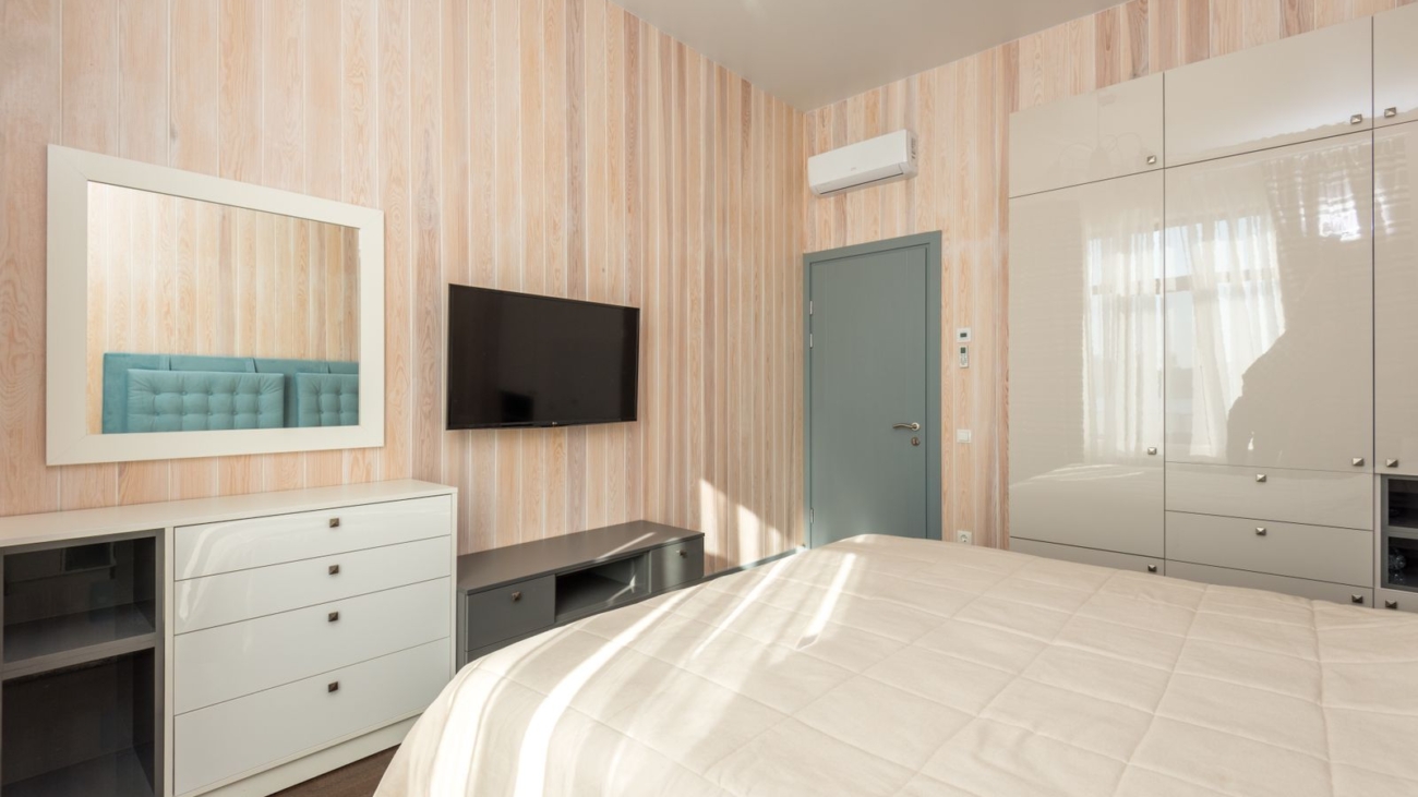 10x12 master bedroom layout in a Bengaluru apartment 2026 showing full-height wardrobe, door and AC indoor unit against a queen bed wall, by myNivasa