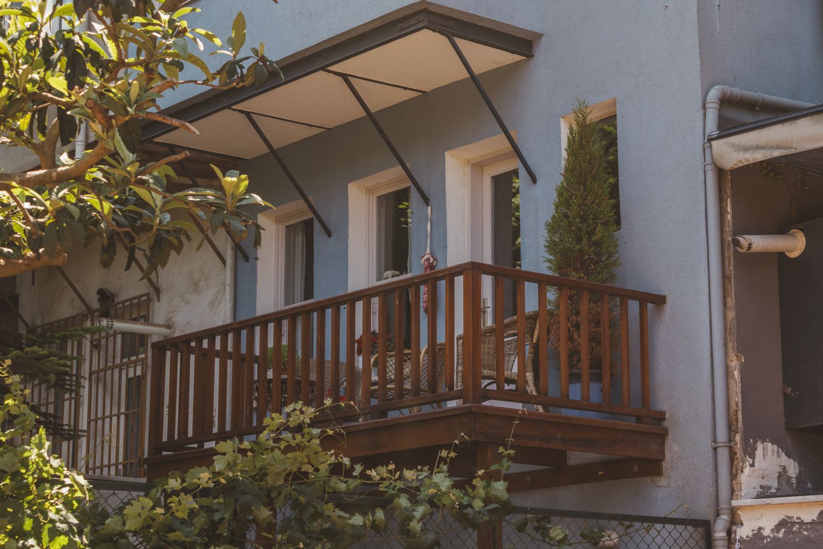 Balcony with fixed awning, wooden railing and seating, weather-proofed balcony design Bengaluru 2026, by myNivasa