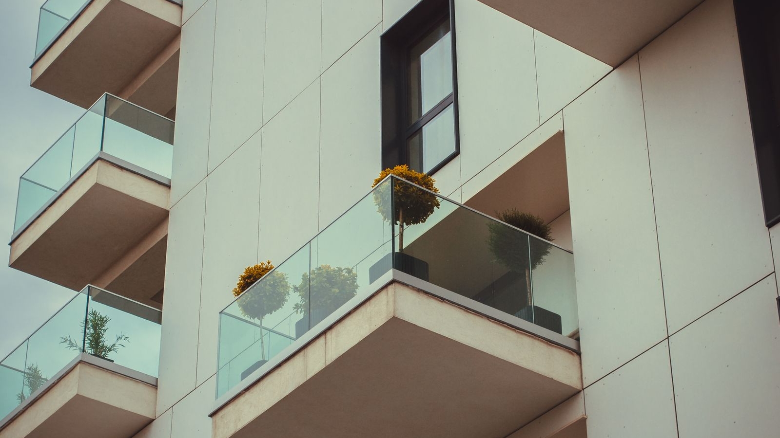 Open apartment balconies with glass railings and planters, balcony design Bengaluru 2026, by myNivasa