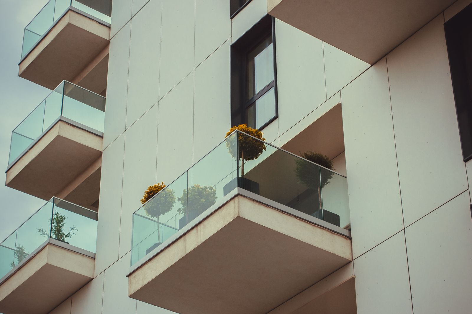 Open apartment balconies with glass railings and planters, balcony design Bengaluru 2026, by myNivasa