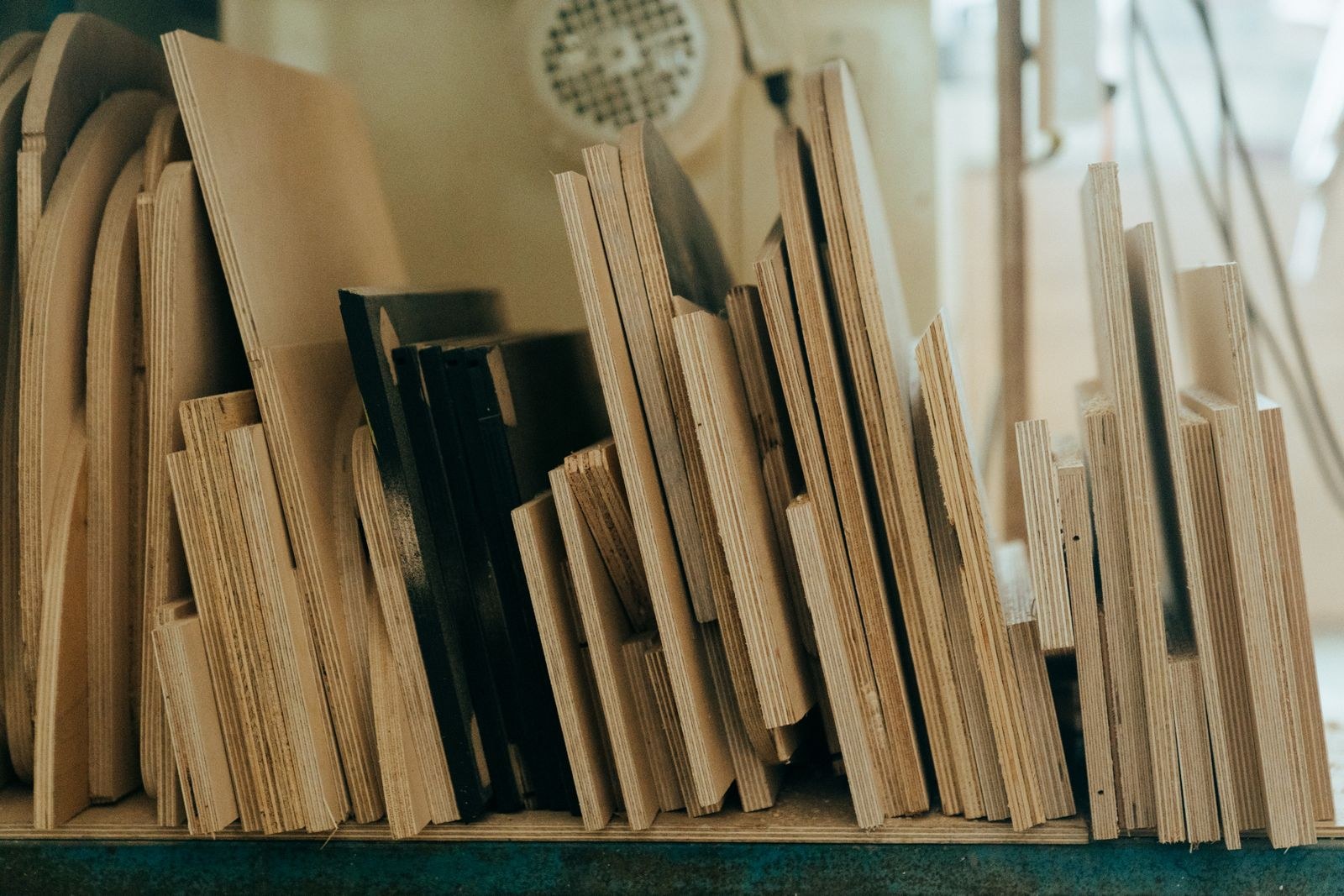Stacked plywood sheets of different grades and thicknesses in a Bengaluru workshop 2026, showing edge veneer layers, by myNivasa