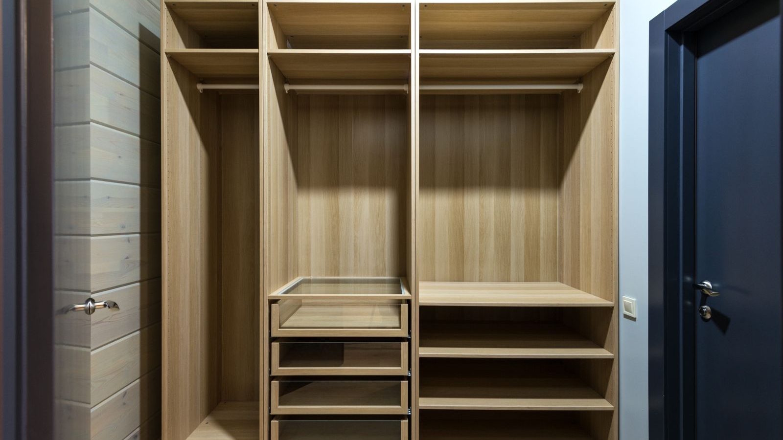 Open wardrobe carcass with shelves and hanging rods in a Bengaluru bedroom, 2026, showing cut edges and internal layout, by myNivasa