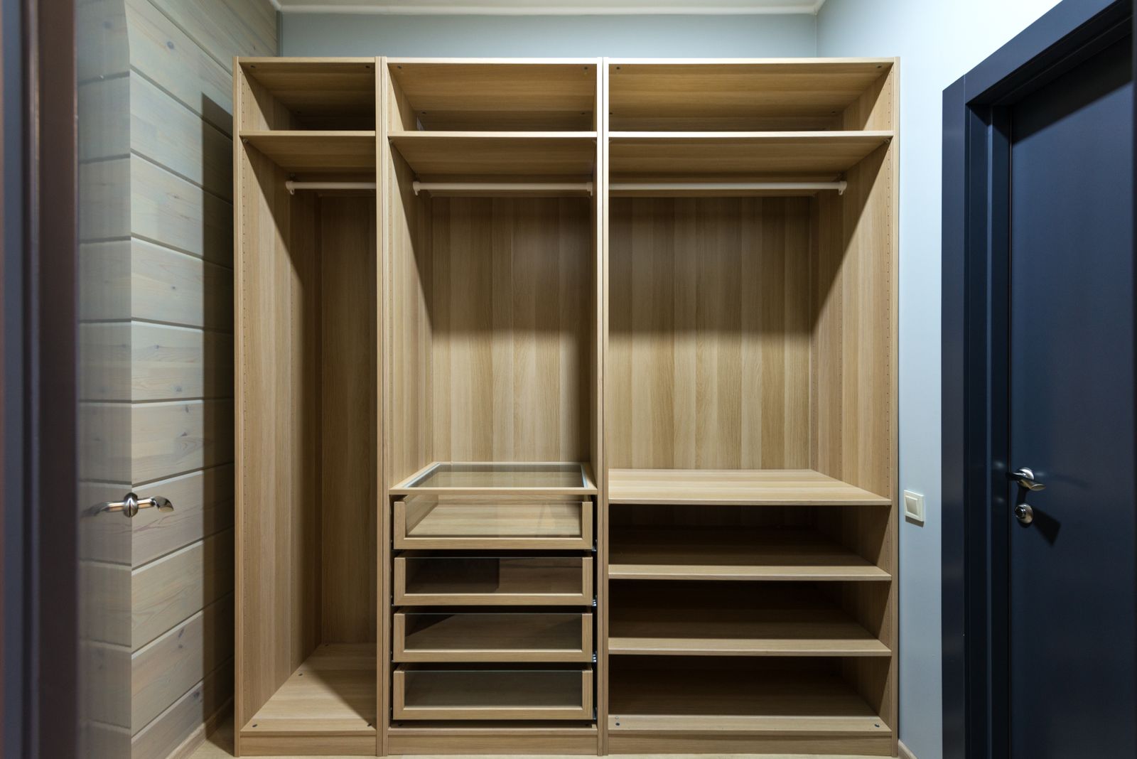 Open wardrobe carcass with shelves and hanging rods in a Bengaluru bedroom, 2026, showing cut edges and internal layout, by myNivasa