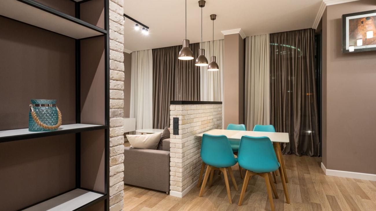 Half height brick partition between a living area and a dining area in an apartment, an example of a living dining partition in Bengaluru 2026, by myNivasa