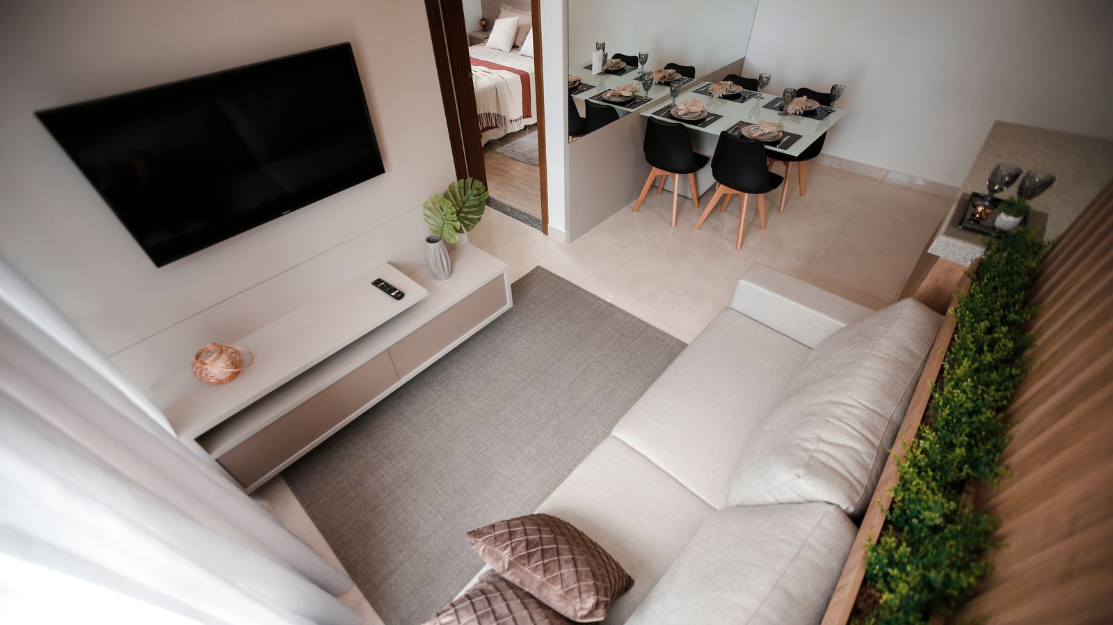 Open plan living and dining area zoned with a low planter divider and a rug instead of a built partition, an alternative approach for small Bengaluru apartments in 2026, by myNivasa