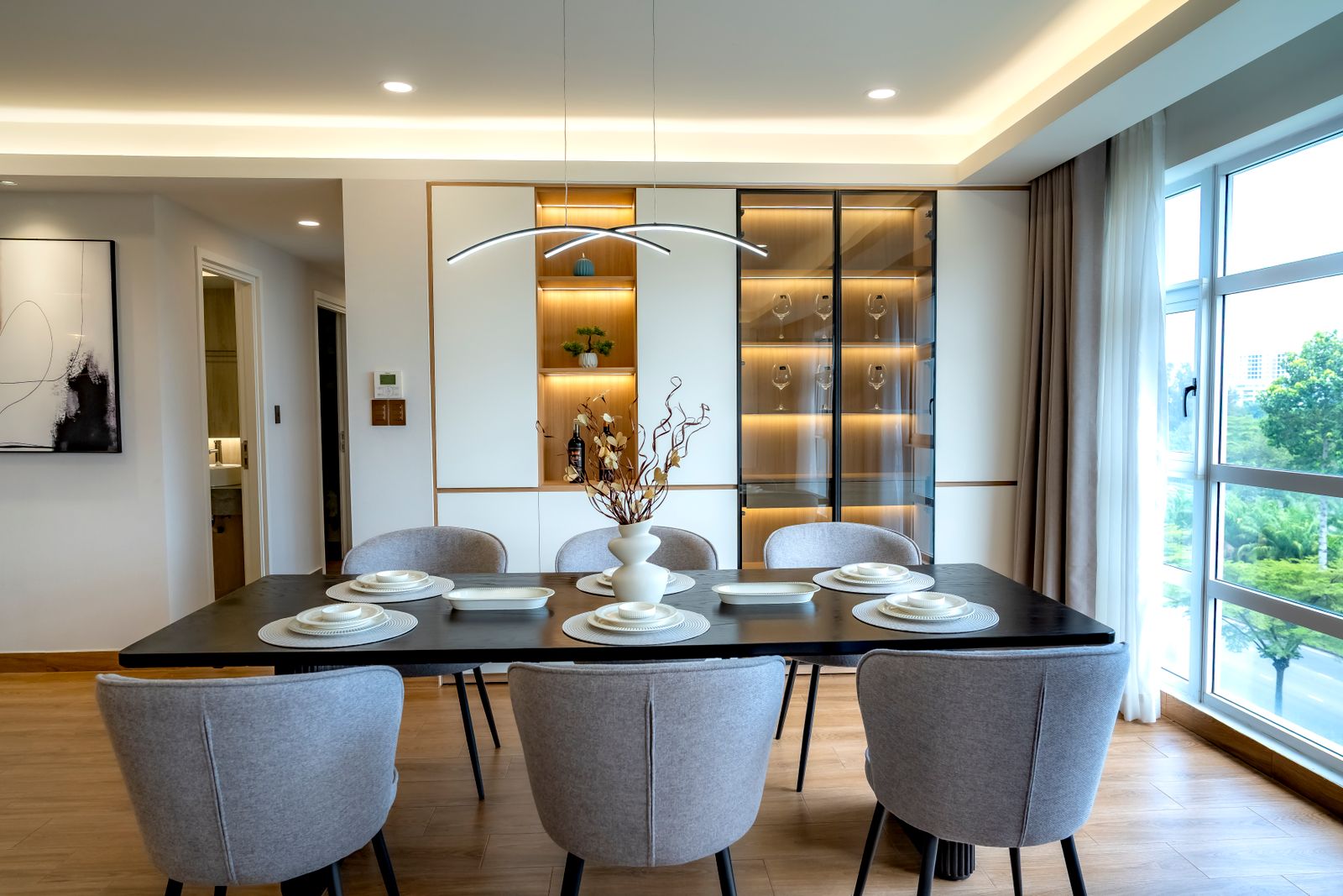 Built in dining wall with a lit glass shutter crockery unit and open niches in a Bengaluru flat 2026 by myNivasa