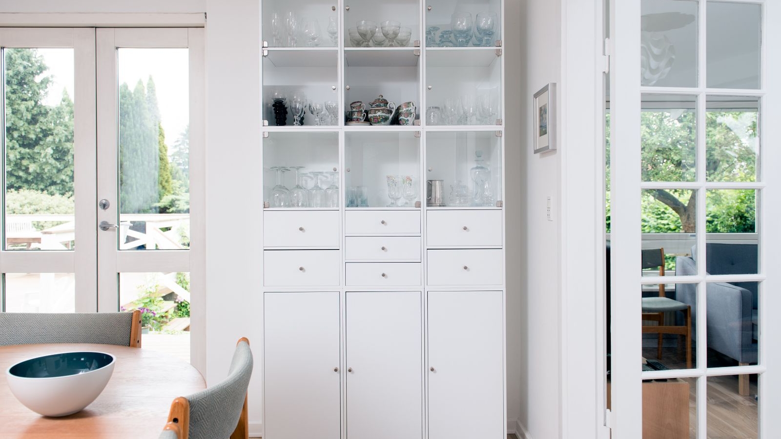 Full height glass front crockery unit beside a dining table in a Bengaluru apartment 2026 by myNivasa
