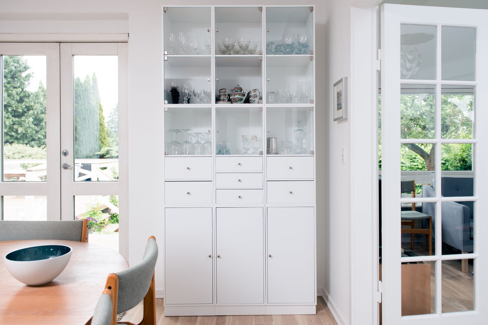 Full height glass front crockery unit beside a dining table in a Bengaluru apartment 2026 by myNivasa