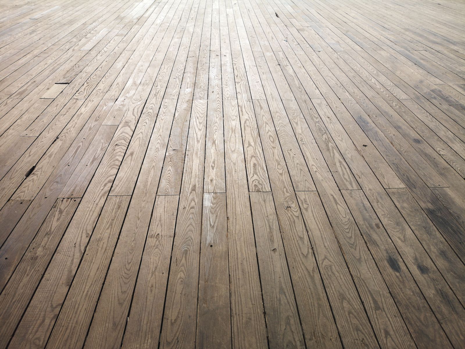 Close view of wooden floor planks in Bengaluru showing seasonal gaps opening between boards during the dry March months