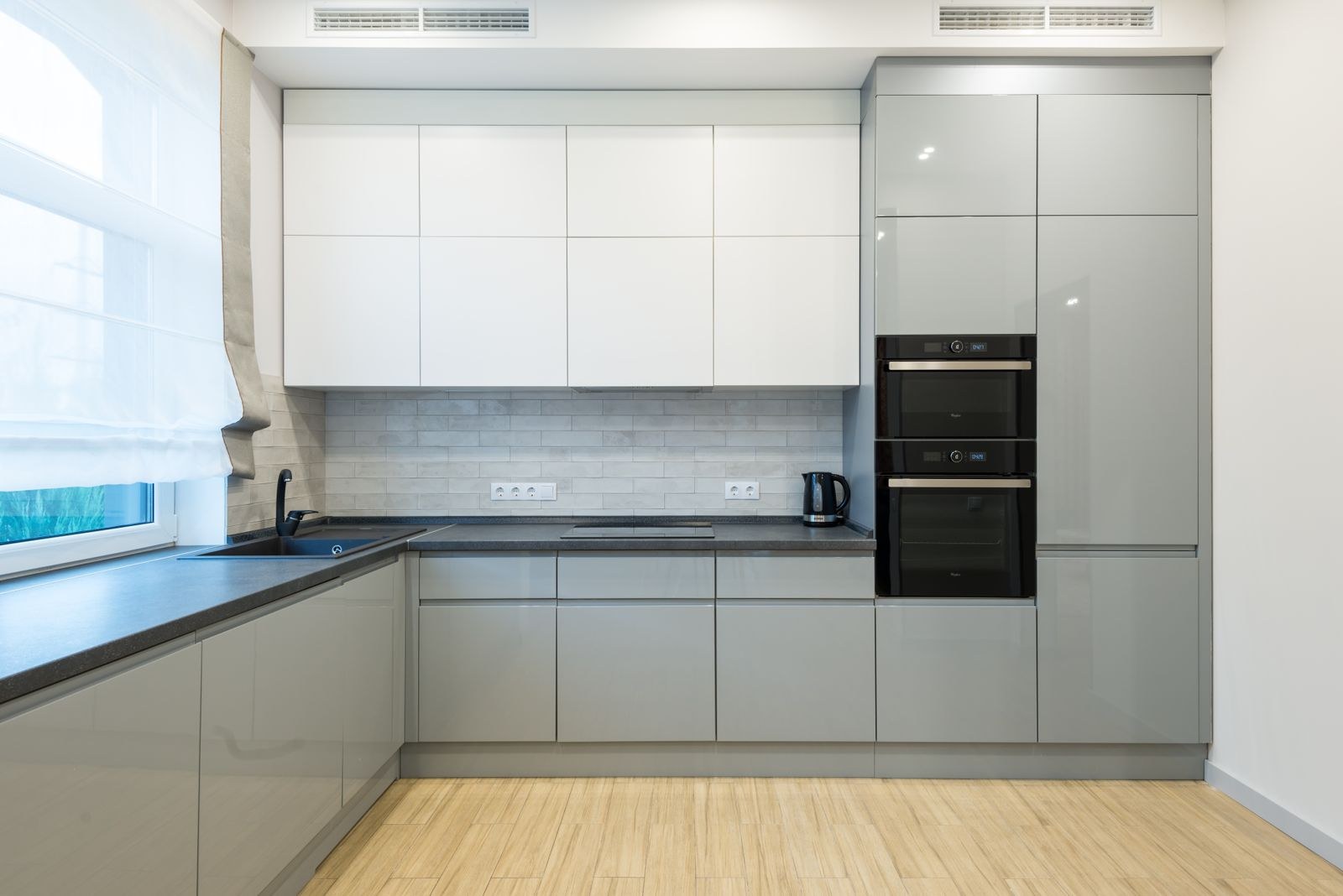 L shaped grey and white kitchen with a sink run, built in ovens and a kettle on the counter, edge banding wet zone guide Bengaluru 2026, by myNivasa