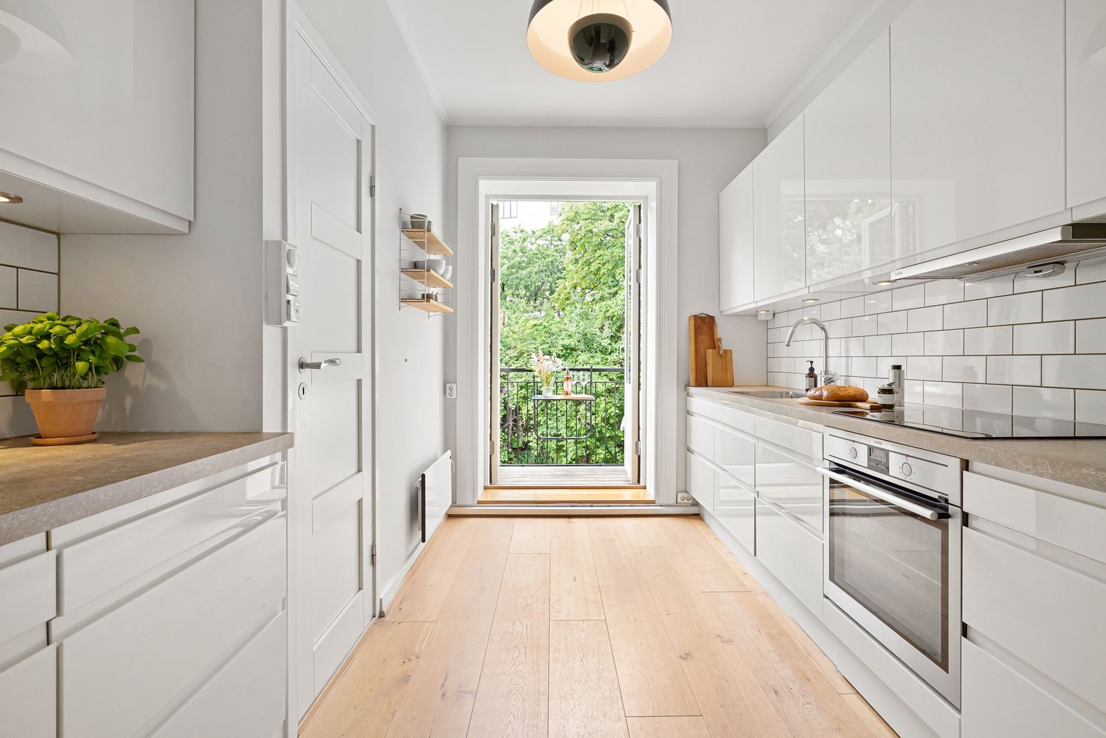 Parallel galley modular kitchen with white cabinets and wooden floor, layout cost guide Bengaluru 2026, by myNivasa